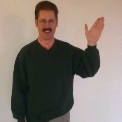 man wearing a mustache and waving