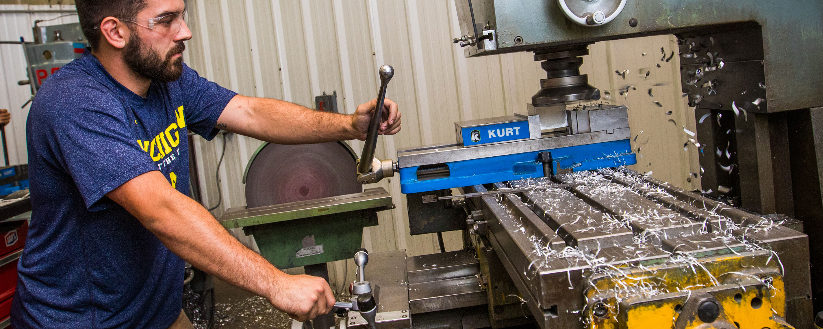 Header image showing Aggressive Tooling employee using a machine to cut metal